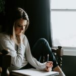 Une femme qui écrit à une fenêtre
