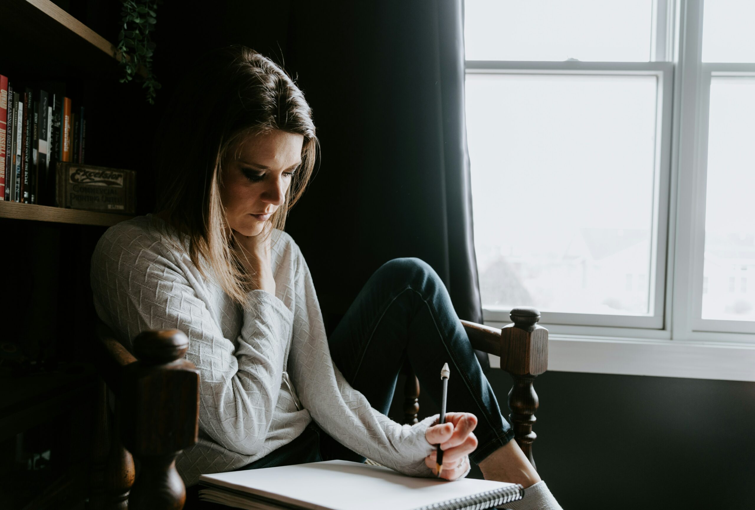 Une femme qui écrit à une fenêtre